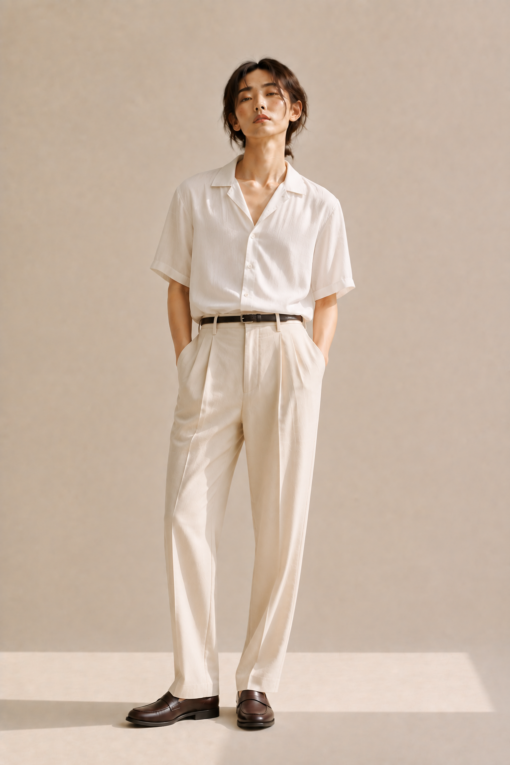 Silky short-sleeve shirt tucked into pleated trousers with a thin belt and loafers, an elevated summer acubi outfit.