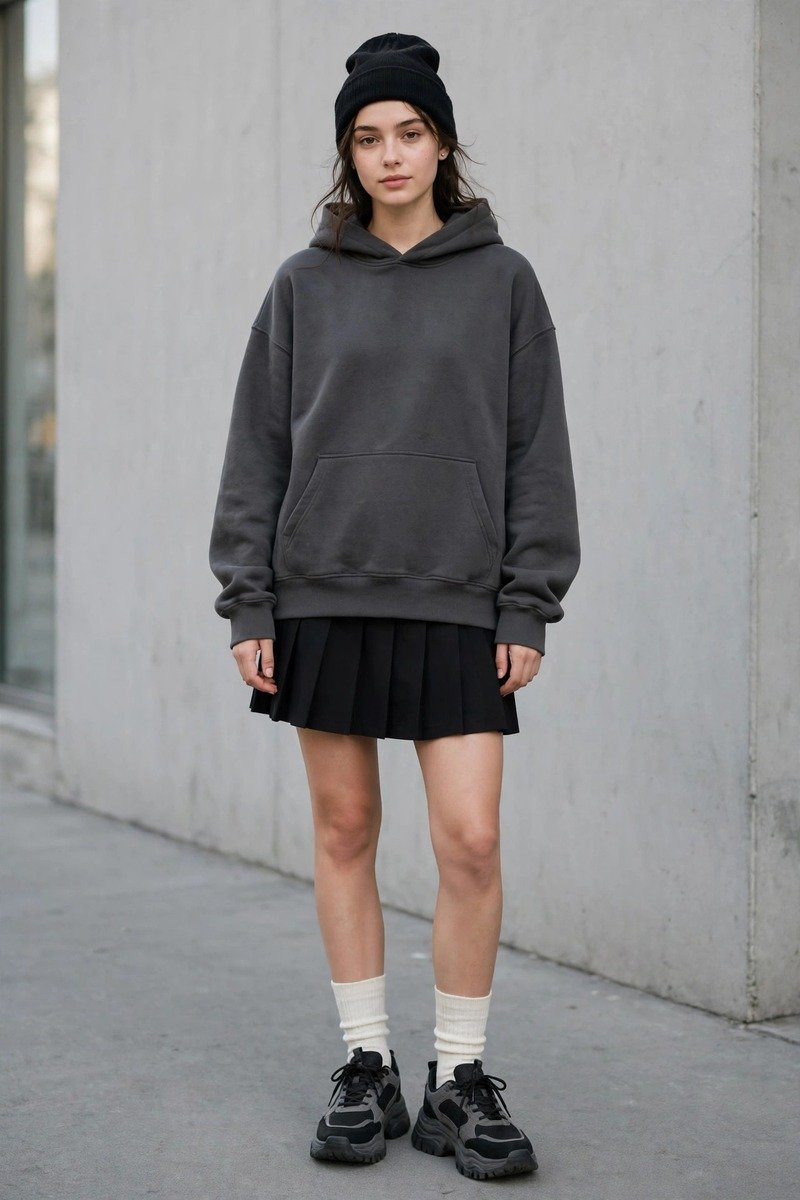 Oversized charcoal grey hoodie paired with a pleated black mini skirt in acubi streetwear style