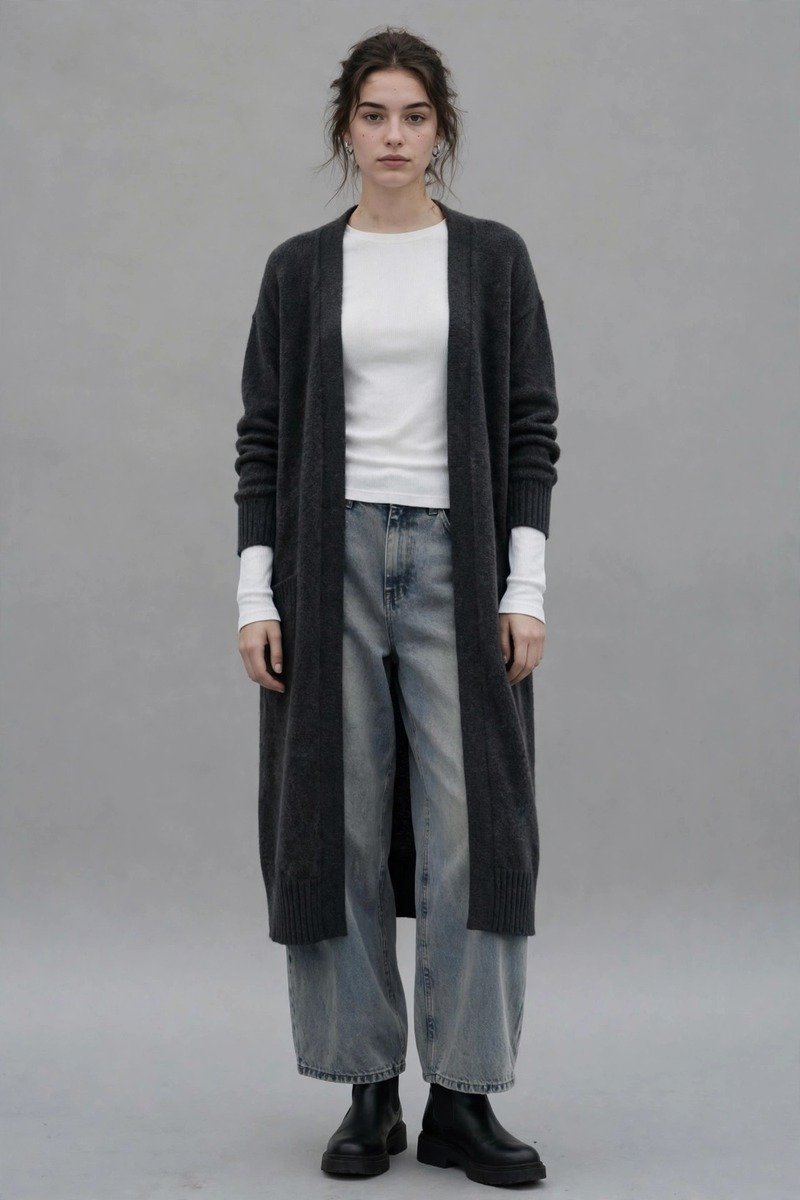Woman in a white thermal long-sleeve under a long charcoal cardigan with faded wide-leg jeans and black ankle boots